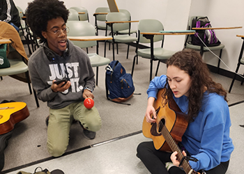 Music Therapy Students - one with maracas and one with a guitar
