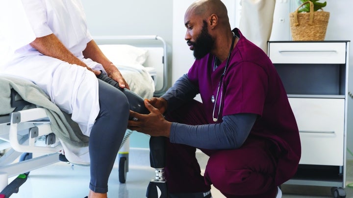Health care professional fitting a prosthetic