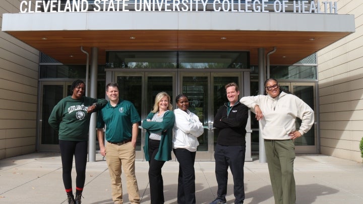 Academic Coaches in front of College of Health sign