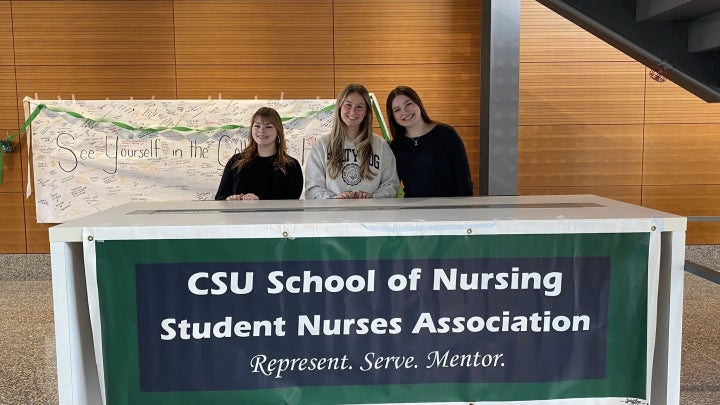 Students representing student Nurses Association at a table