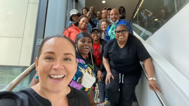 Cohort of students of the Community Health Worker program posing on a stairway