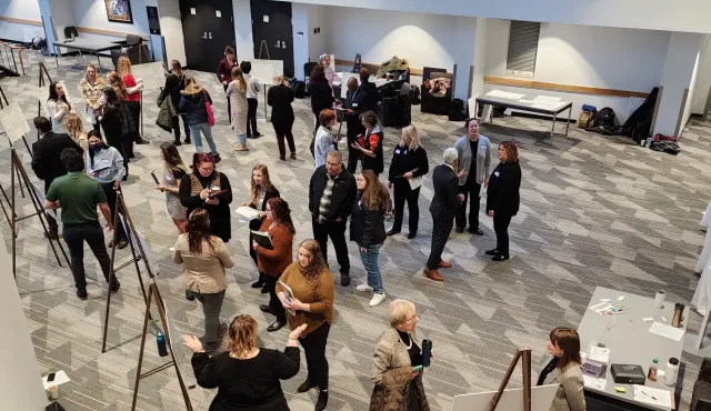 An image of students and faculty taken from above gathering around posters of clinical sessions