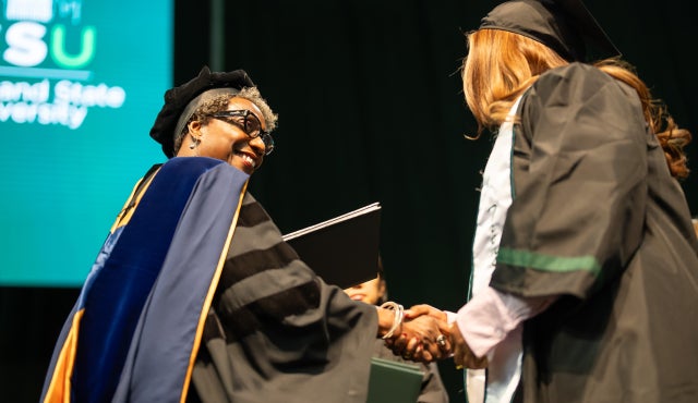 Fall 2025 graduation with Dean handing diploma to student