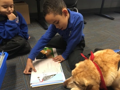child reading with therapy dog