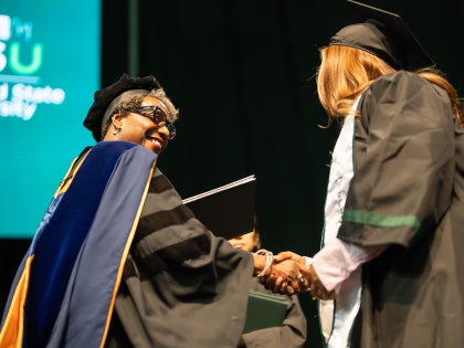 Fall 2025 graduation with Dean handing diploma to student