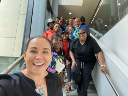 Cohort of students of the Community Health Worker program posing on a stairway